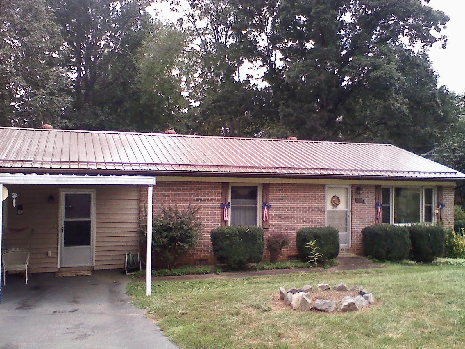 Bronze metal roof and carport on a brick ranch home — Roof Repair work by our crew in Lake Mary